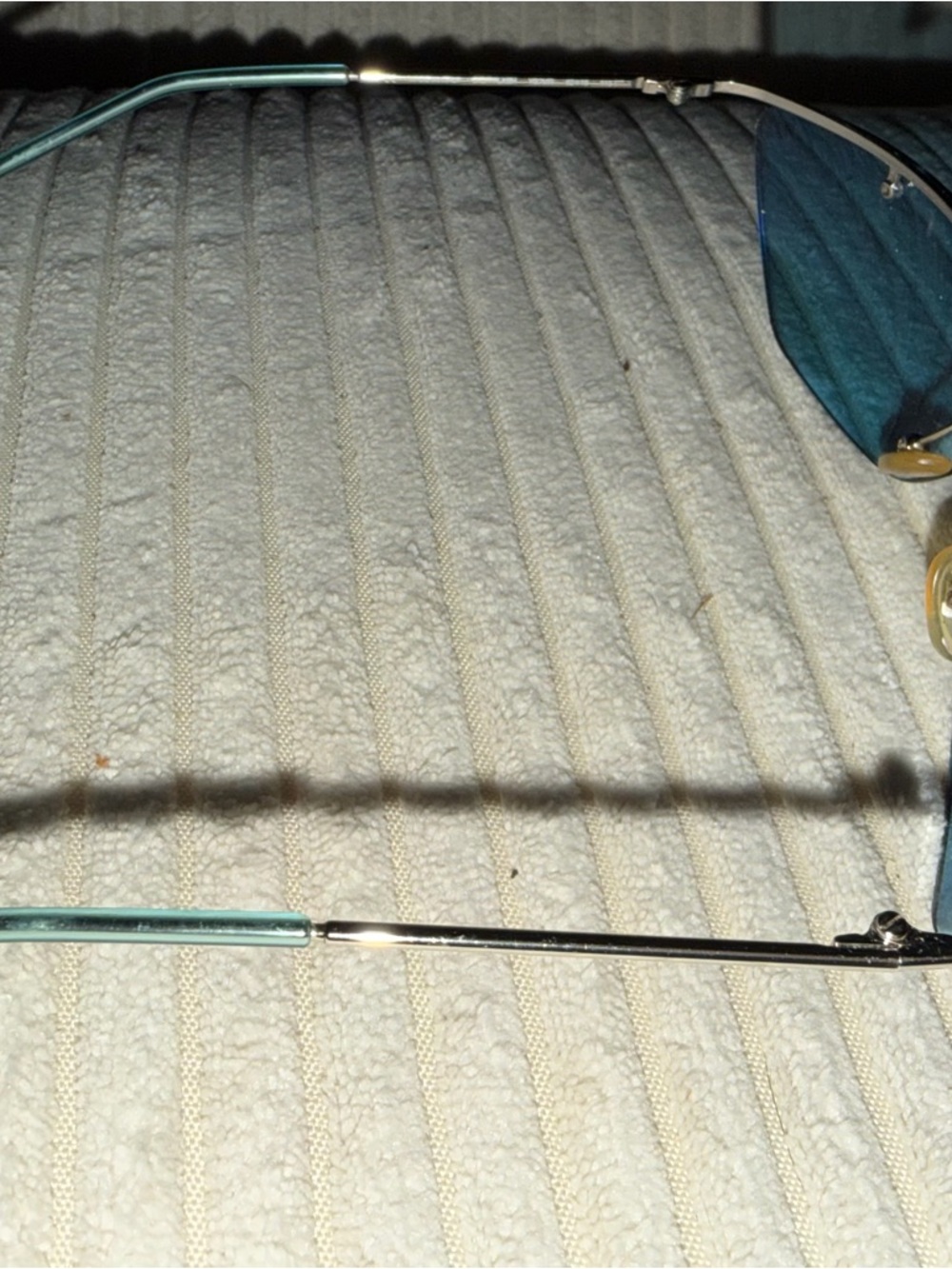 Dior Silver Logo Detail on Light Teal Surface - Picture 5 of 6